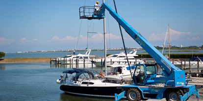 Yachthafen - Stromanschluss - Italien - Hubstapler, Hubkorb und Kran für Arbeiten am Mast. - Marina Punta Gabbiani